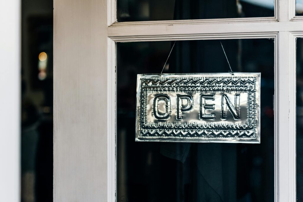 Metal open sign hanging on a shop door in Paso Robles, California.